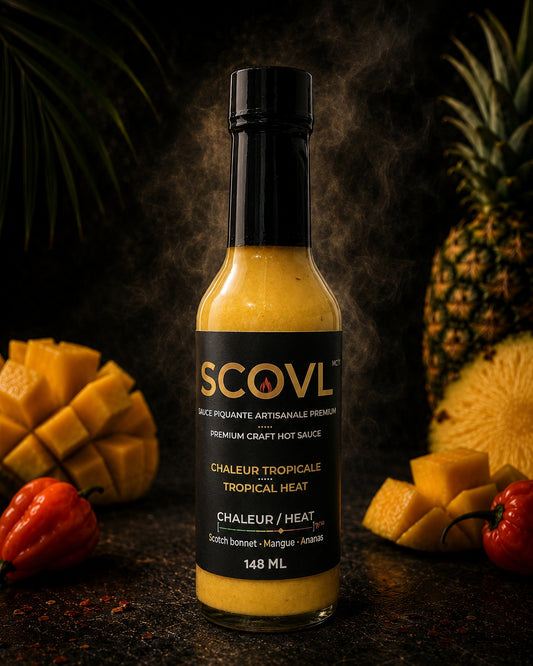A premium studio shot of the SCOVL Tropical Heat hot sauce bottle sitting elegantly next to fresh tropical ingredients like sweet pineapple and spicy scotch bonnet peppers.