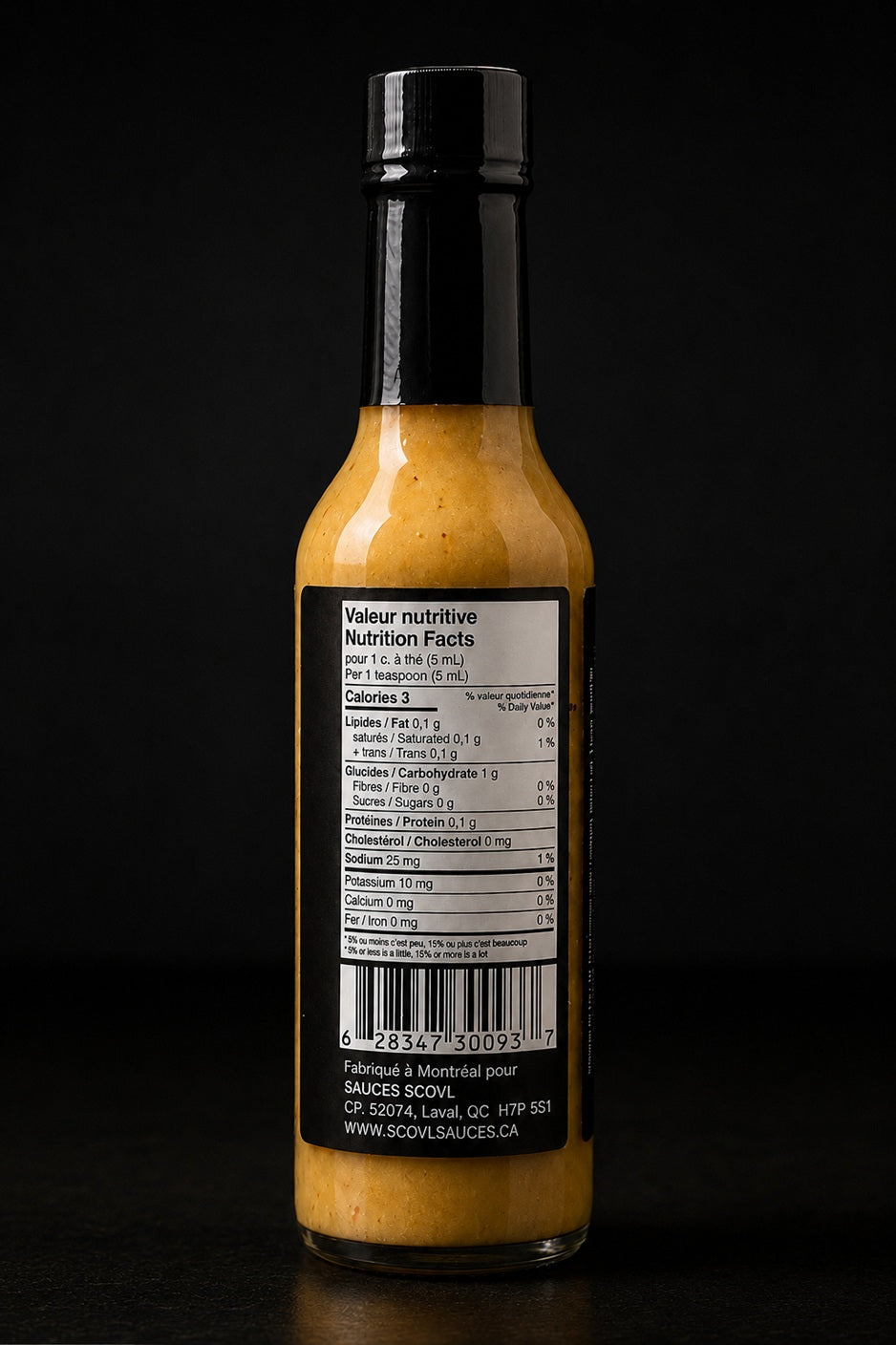 The bilingual Canadian nutrition facts table and ingredient list on the back of the SCOVL Tropical Heat hot sauce bottle label.